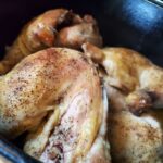 A picture of cooked chicken thighs in a Dutch oven.