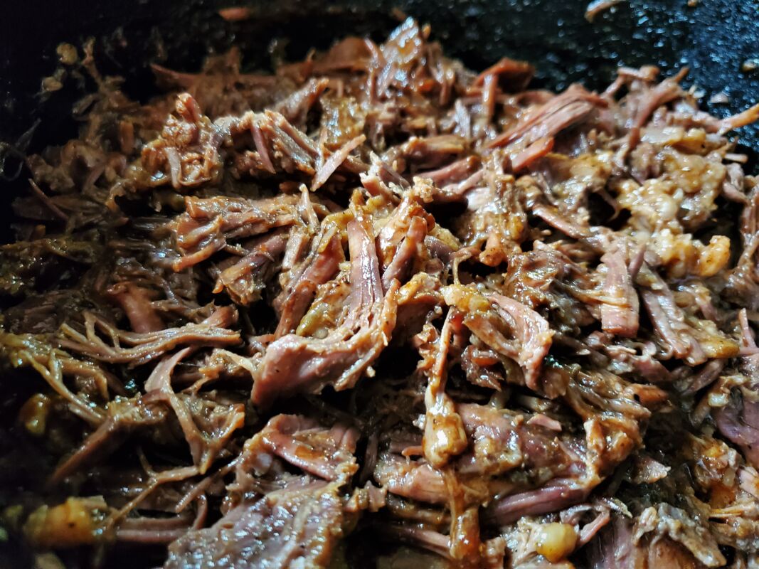 A picture of shredded chuck roast BBQ in a Dutch oven.