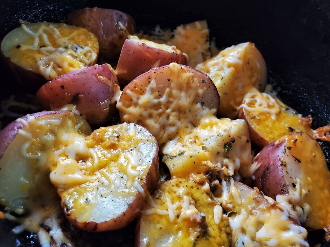 A picture of cheesy Dutch oven potatoes.