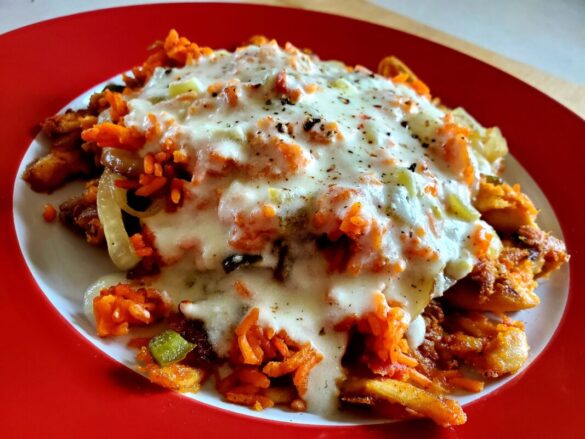 A picture of Arroz con Pollo on a plate, covered in queso.